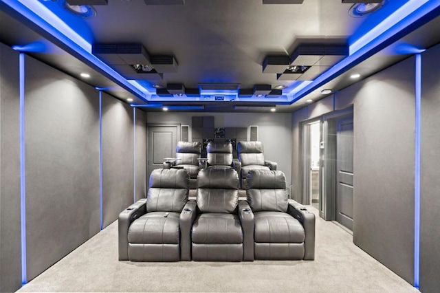 home theater featuring carpet flooring and a raised ceiling