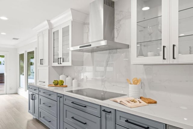 kitchen with white cabinetry, black electric stovetop, gray cabinets, and wall chimney range hood