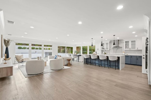 living room with ornamental molding and light hardwood / wood-style flooring