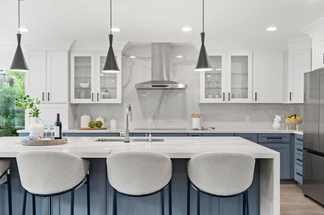 kitchen featuring decorative light fixtures, stainless steel fridge, and island exhaust hood