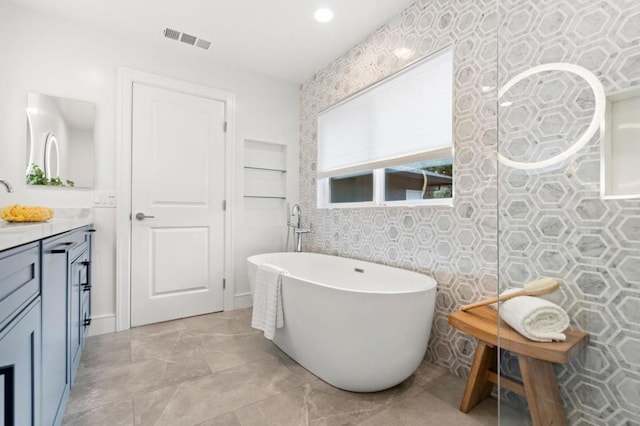 bathroom with vanity and a bath