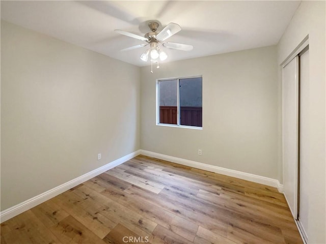 unfurnished bedroom featuring light hardwood / wood-style flooring, a closet, and ceiling fan