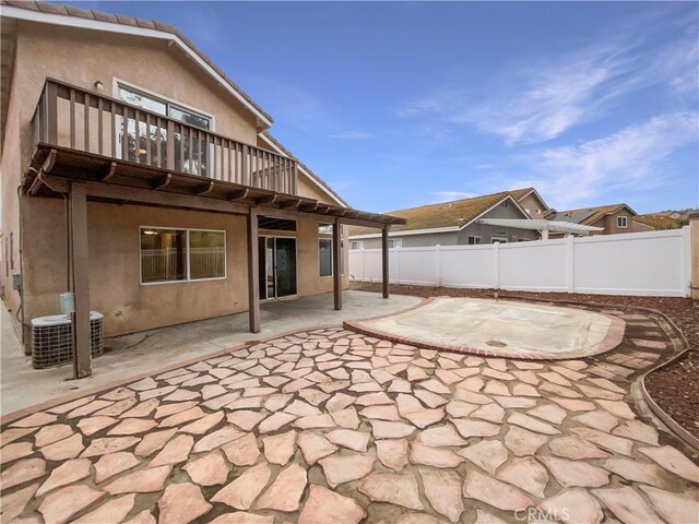 view of patio with central AC and a balcony