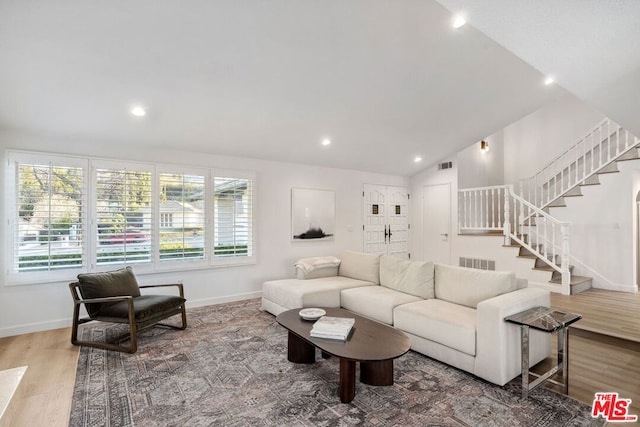 living room featuring wood-type flooring and lofted ceiling