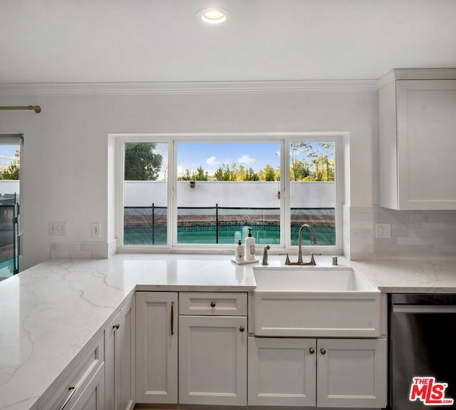 kitchen with sink, crown molding, light stone countertops, decorative backsplash, and stainless steel dishwasher