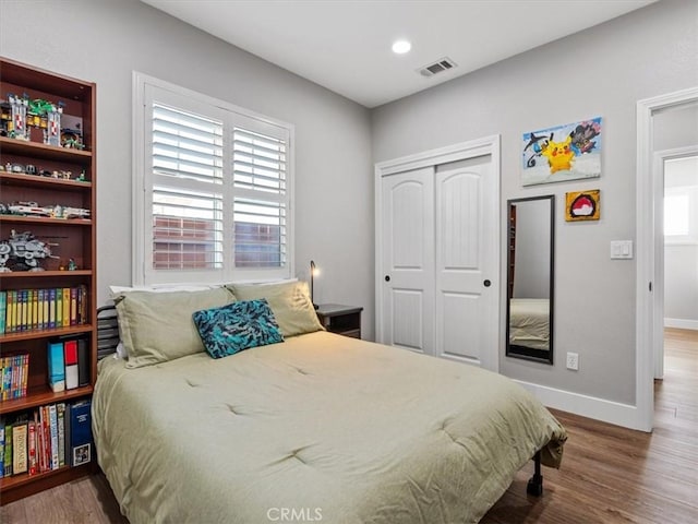 bedroom with hardwood / wood-style floors and a closet