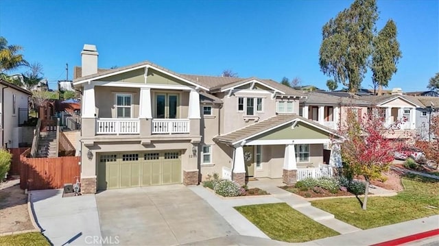 view of front of property with a garage, a balcony, and covered porch