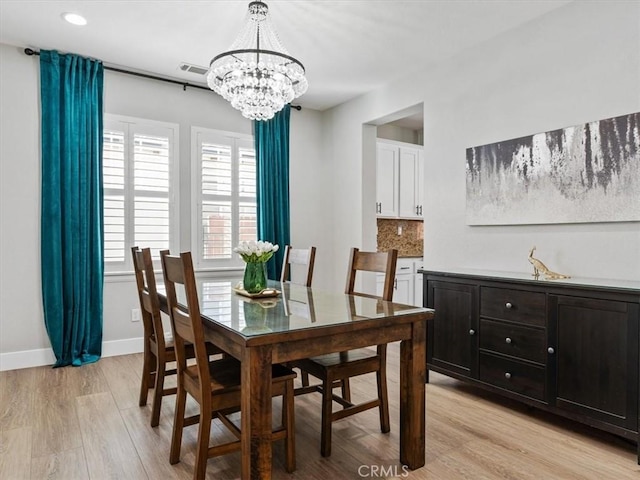 dining space with an inviting chandelier and light hardwood / wood-style floors