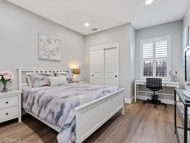 bedroom with hardwood / wood-style floors and a closet