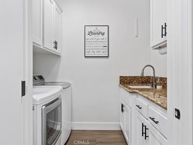 washroom with cabinets, sink, dark wood-type flooring, and washer and clothes dryer