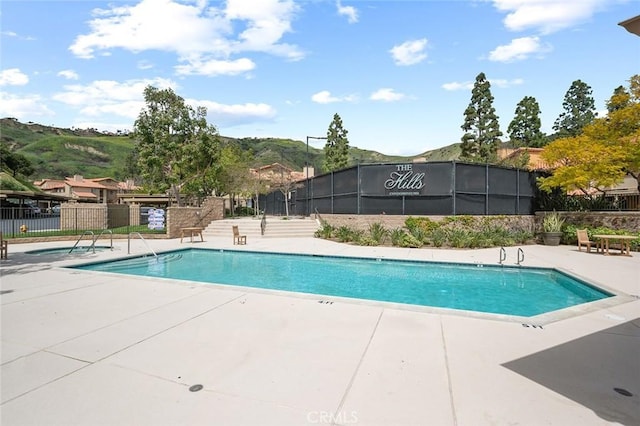 view of pool with a patio and a mountain view