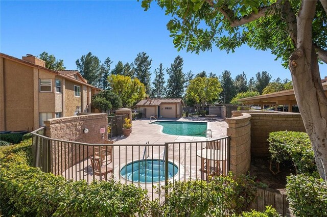 view of pool with a hot tub and a patio