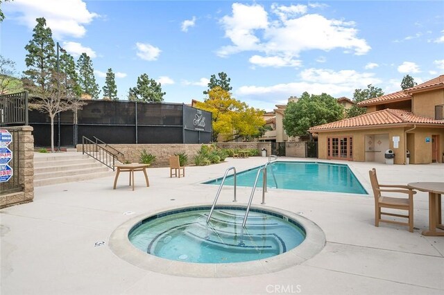 view of swimming pool with a community hot tub and a patio area