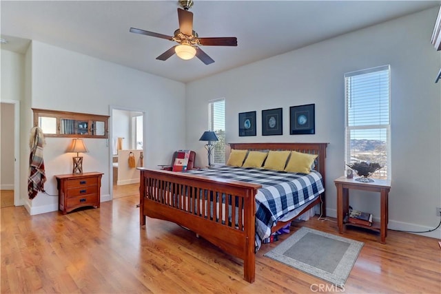 bedroom with ceiling fan, ensuite bathroom, and light wood-type flooring