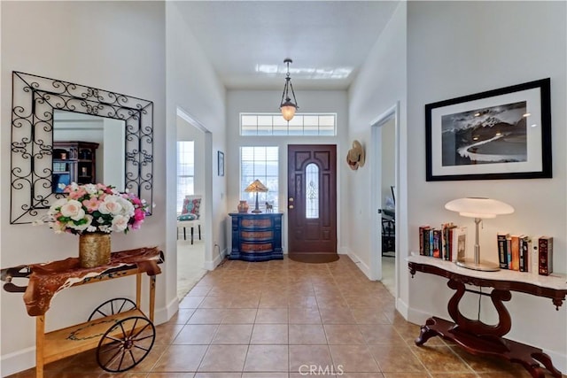 entryway featuring tile patterned flooring and a towering ceiling