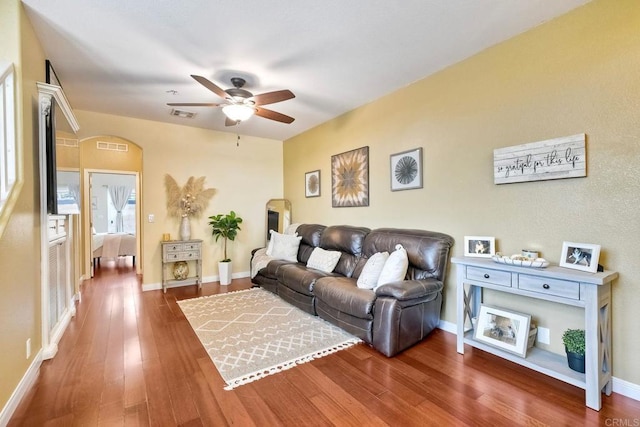 living room with dark wood-type flooring and ceiling fan