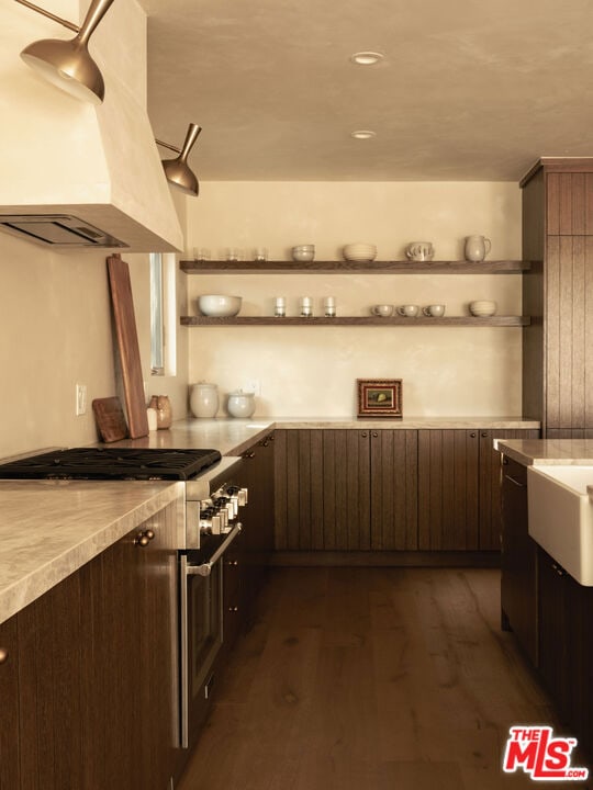 interior space with dark hardwood / wood-style floors, custom range hood, dark brown cabinetry, and high end stove