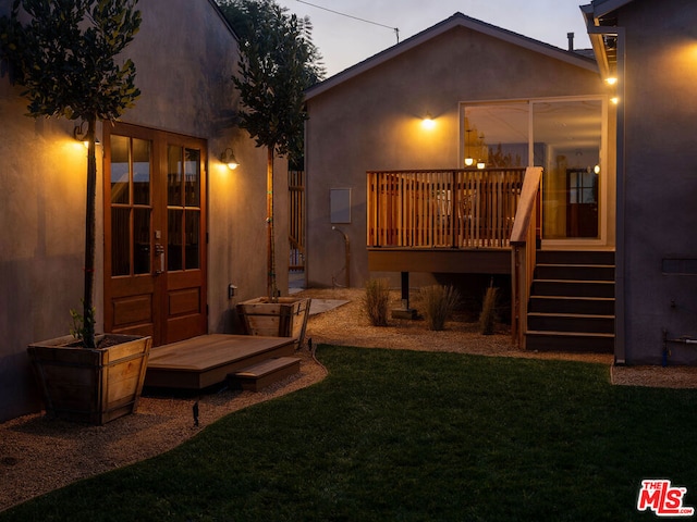 back of property featuring french doors, a yard, and a deck