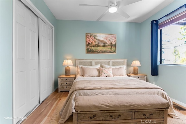 bedroom with ceiling fan, a closet, light hardwood / wood-style floors, and multiple windows