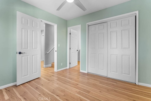 unfurnished bedroom with ceiling fan, a closet, and light wood-type flooring