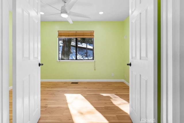 unfurnished bedroom with ceiling fan and light wood-type flooring