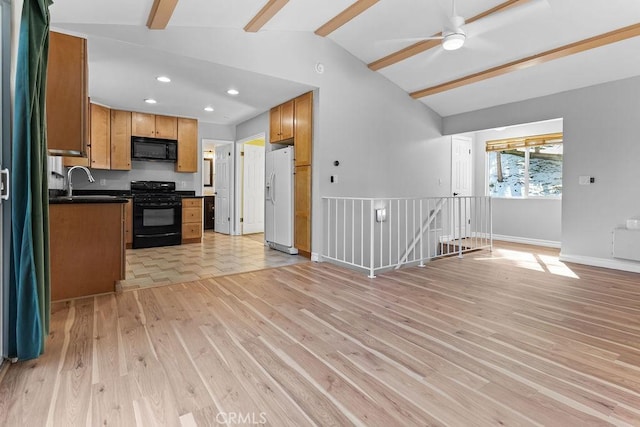 kitchen featuring sink, ceiling fan, vaulted ceiling with beams, black appliances, and light hardwood / wood-style floors