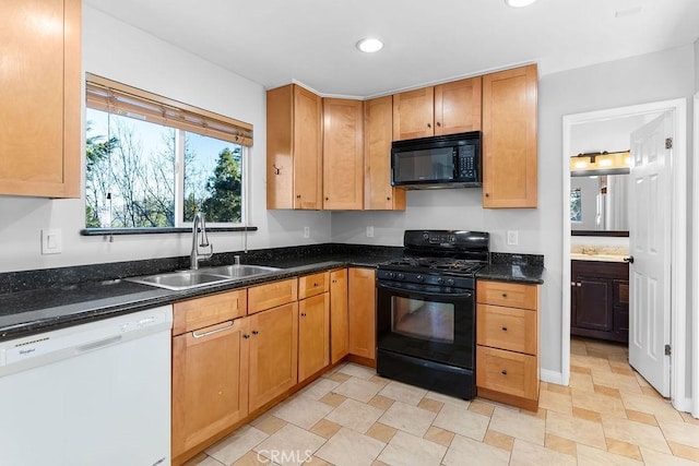 kitchen featuring dark stone countertops, sink, and black appliances