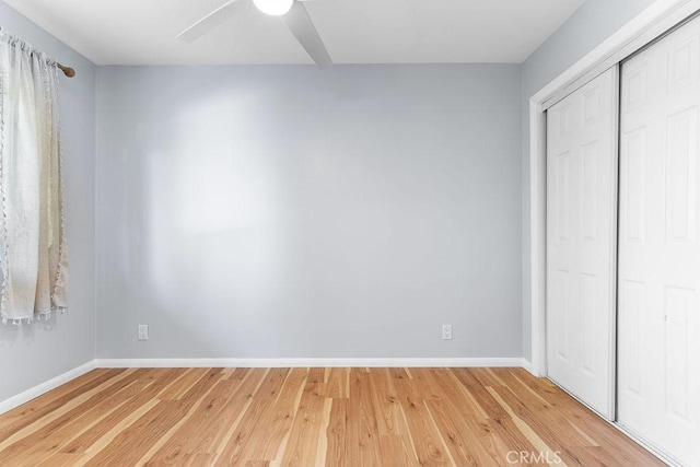 unfurnished bedroom with light hardwood / wood-style floors, a closet, and ceiling fan