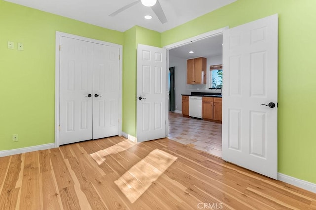 unfurnished bedroom featuring ceiling fan, sink, light hardwood / wood-style floors, and a closet