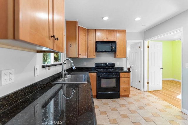 kitchen with dark stone countertops, sink, and black appliances