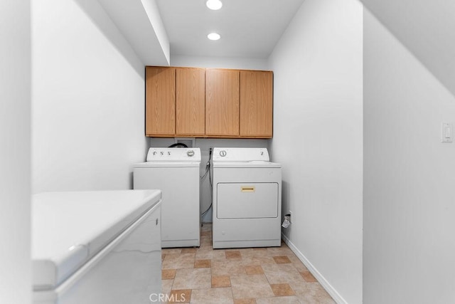 clothes washing area with independent washer and dryer and cabinets