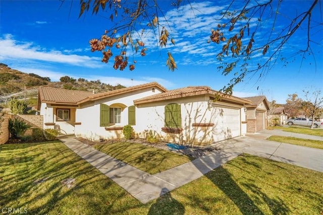 mediterranean / spanish-style house with a garage and a front lawn