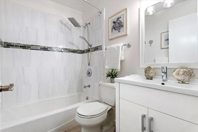 full bathroom with vanity, tiled shower / bath, and toilet