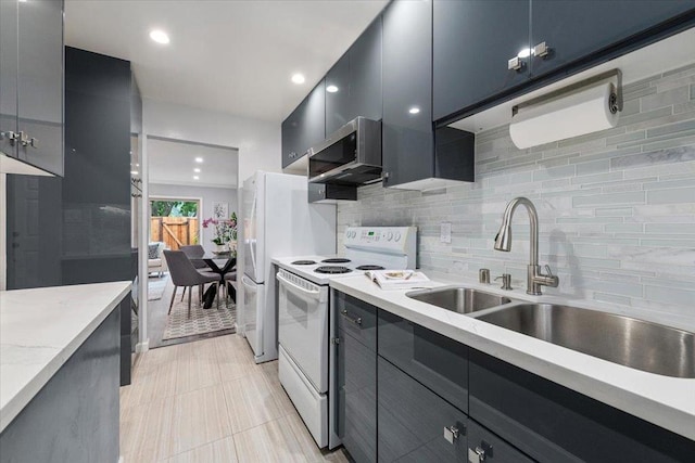 kitchen featuring light stone counters, sink, white appliances, and decorative backsplash