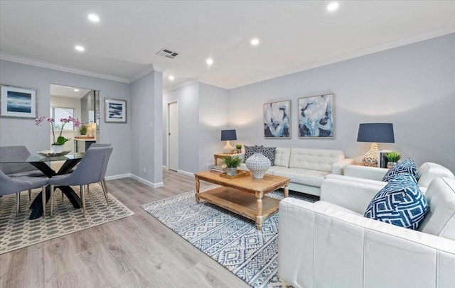 living room with ornamental molding and light hardwood / wood-style flooring