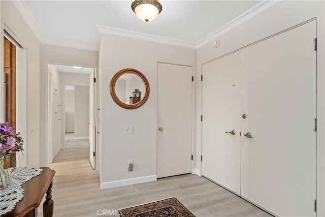 foyer entrance with crown molding and light hardwood / wood-style flooring