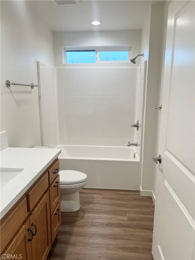 full bathroom featuring wood-type flooring, vanity, shower / bathtub combination, and toilet