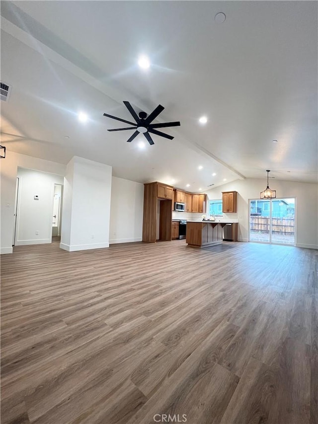 unfurnished living room featuring hardwood / wood-style floors, ceiling fan with notable chandelier, and vaulted ceiling