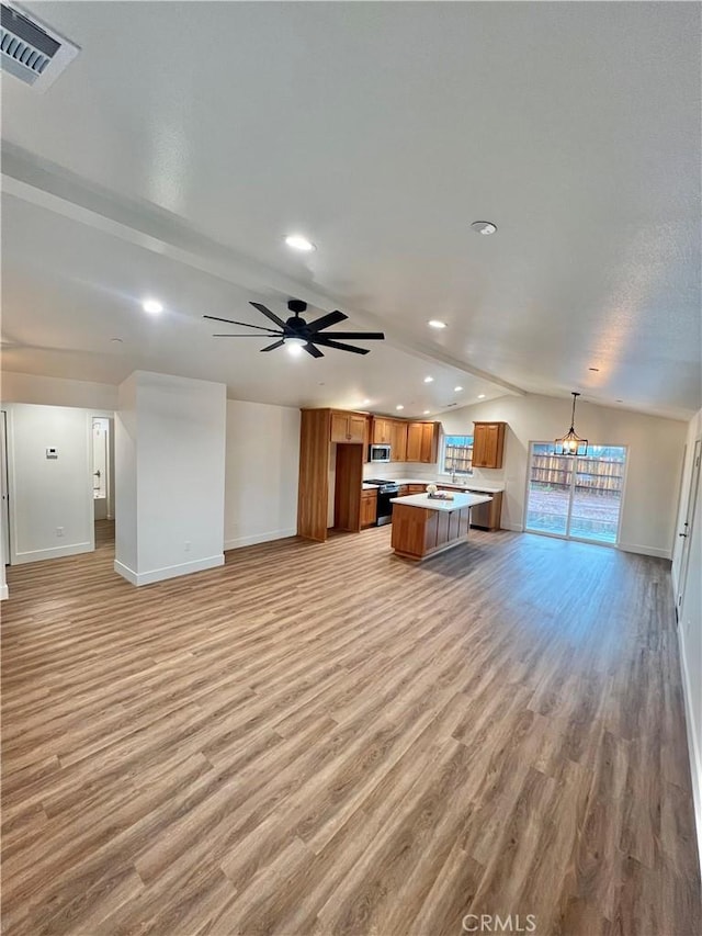 unfurnished living room with lofted ceiling, ceiling fan with notable chandelier, and light wood-type flooring