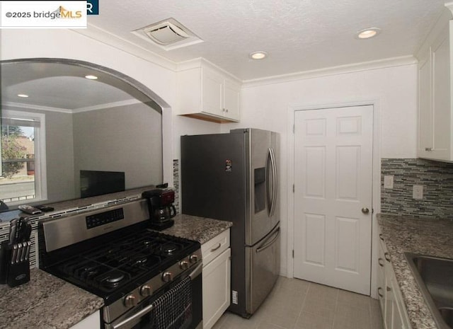 kitchen with crown molding, stainless steel appliances, white cabinets, stone countertops, and decorative backsplash