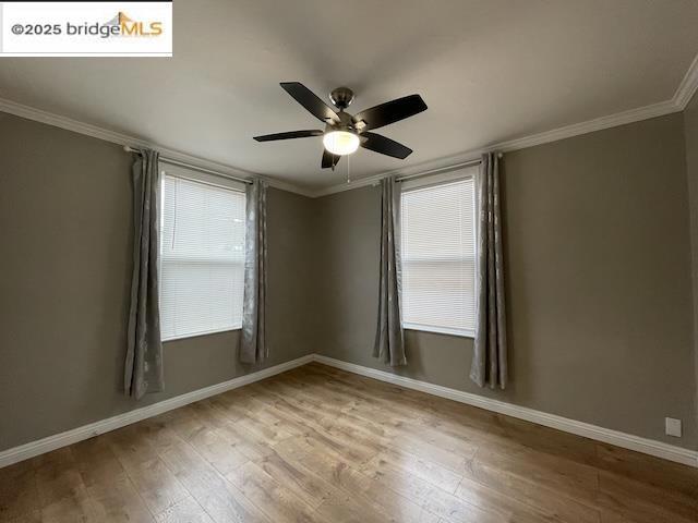 empty room featuring wood-type flooring, ornamental molding, and ceiling fan