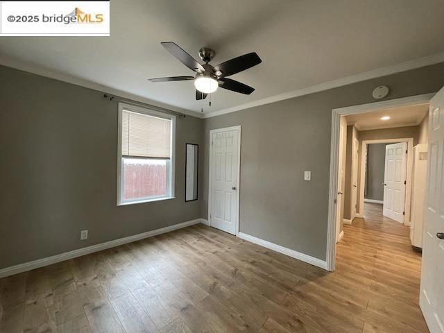 unfurnished bedroom featuring light hardwood / wood-style flooring, ornamental molding, a closet, and ceiling fan