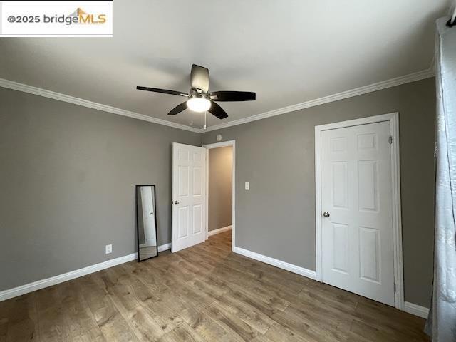 unfurnished bedroom with crown molding, ceiling fan, and hardwood / wood-style floors