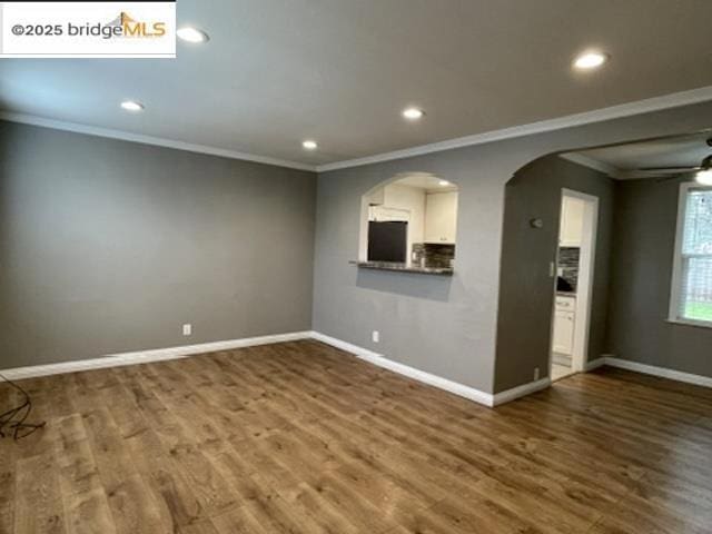 unfurnished living room with hardwood / wood-style floors and ornamental molding