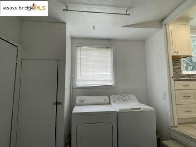 laundry area featuring a textured ceiling and washer and clothes dryer