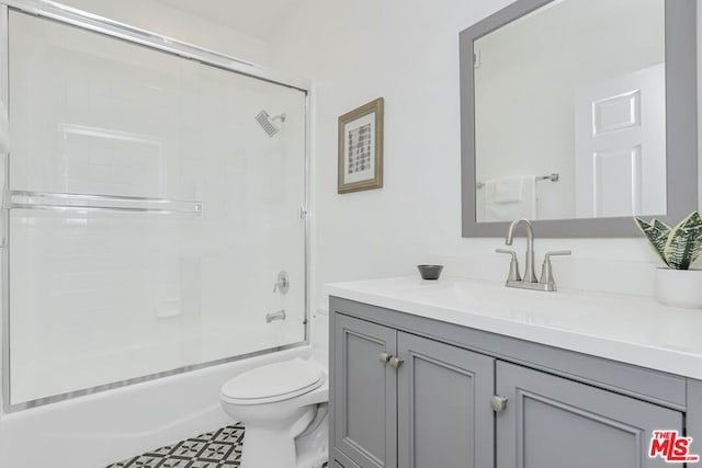 full bathroom with toilet, vanity, and bath / shower combo with glass door