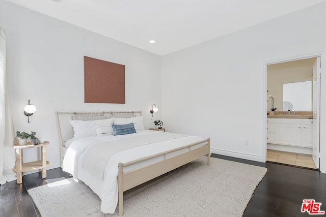 bedroom featuring dark hardwood / wood-style flooring and connected bathroom