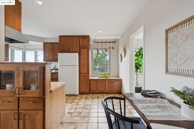 kitchen with light tile patterned floors and white fridge