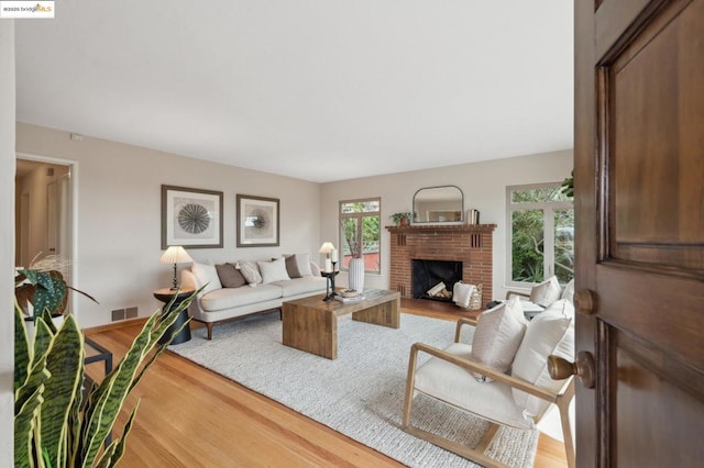 living room featuring hardwood / wood-style flooring and a brick fireplace