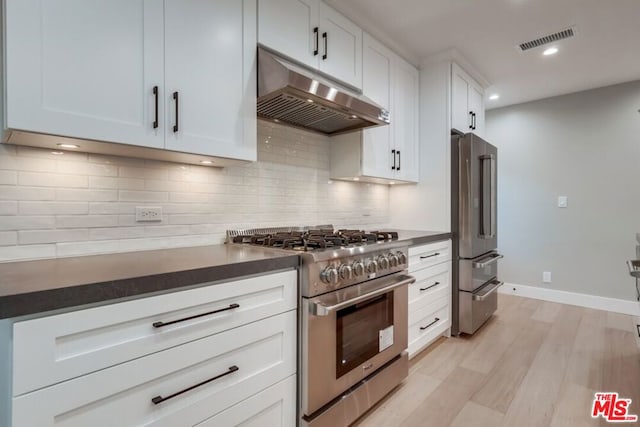 kitchen featuring white cabinetry, high quality appliances, light hardwood / wood-style floors, and backsplash